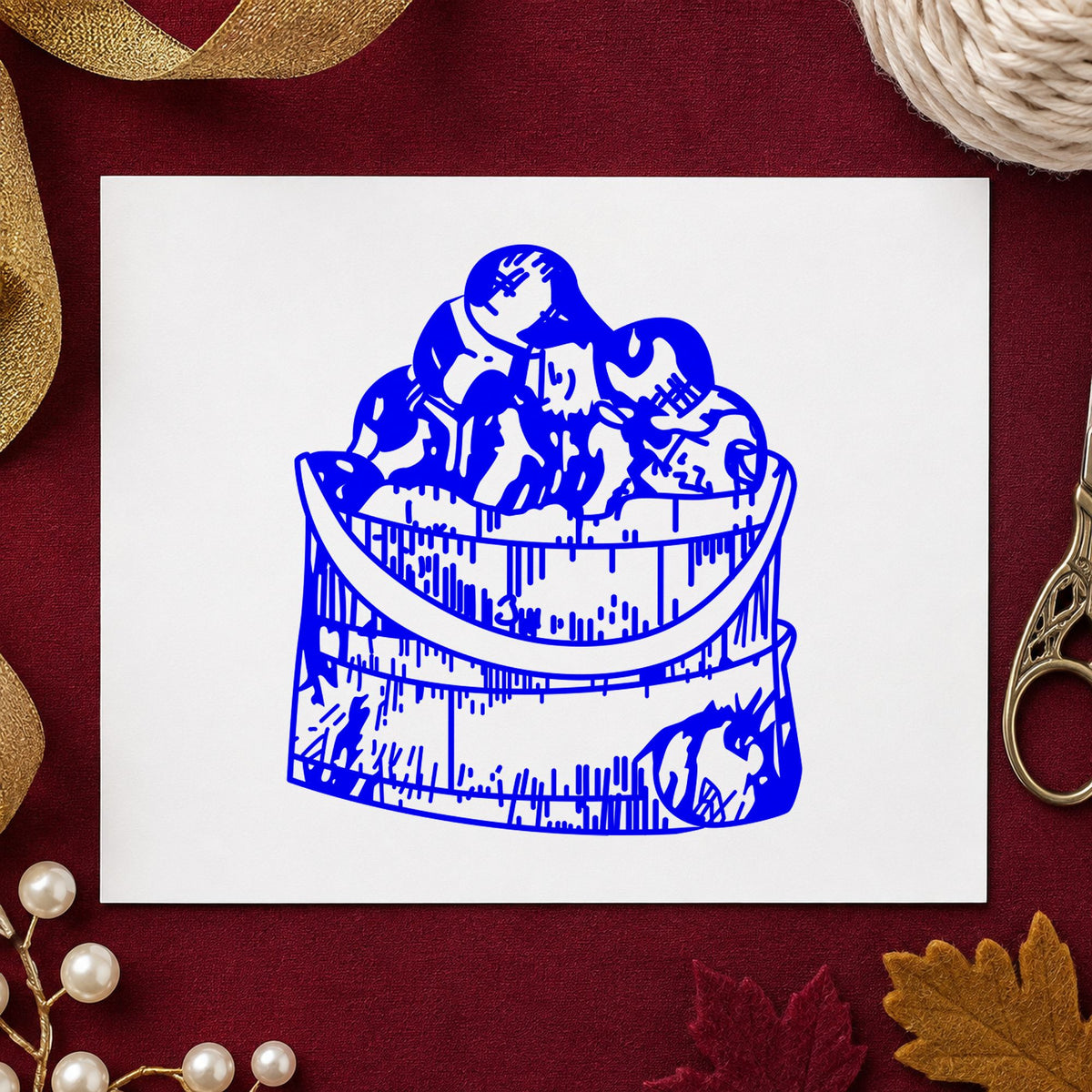 Blue harvest card making stamp impression featuring the wooden bucket of apples design on white paper.