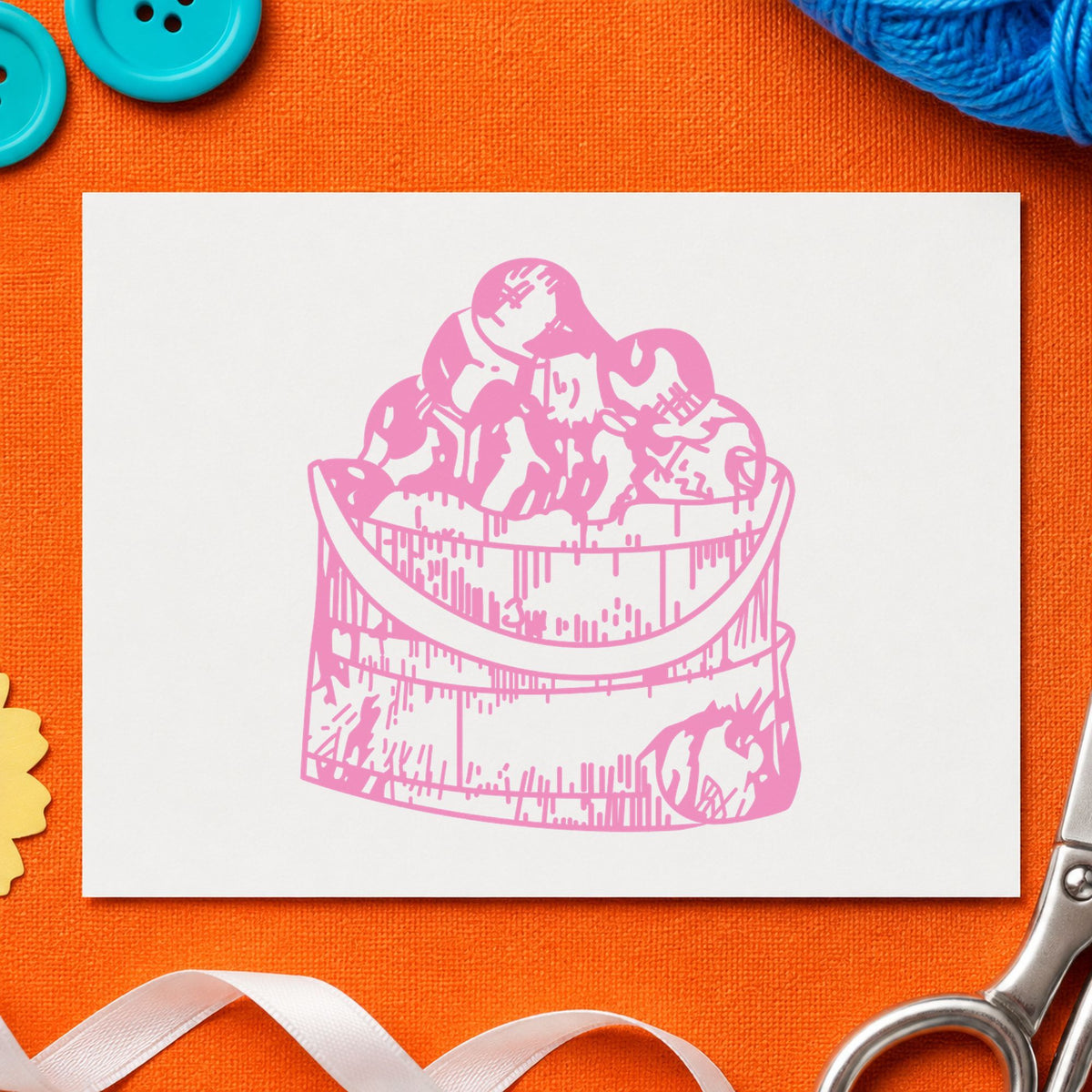 Wooden Bucket of Apples Rubber Stamp impression in pink ink on white paper in a styled craft setting.