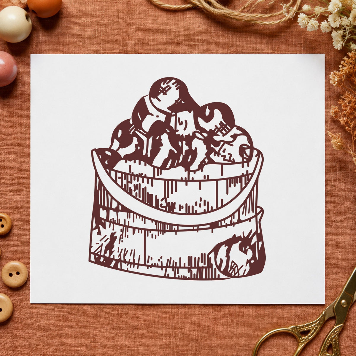 Wooden Bucket of Apples Rubber Stamp impression in brown ink on white paper in a styled craft setting.