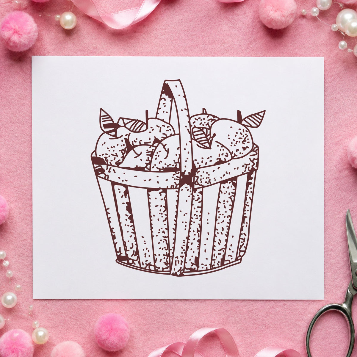 Slatted Apple Basket Rubber Stamp impression in brown ink on white paper in a styled craft setting.