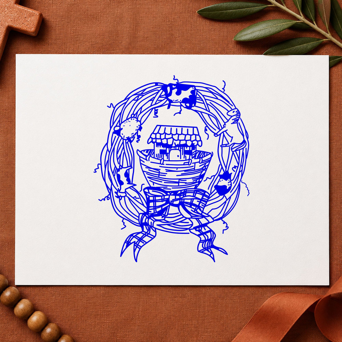 Blue decorative wreath stamp impression featuring the ark in wreath design on white paper.