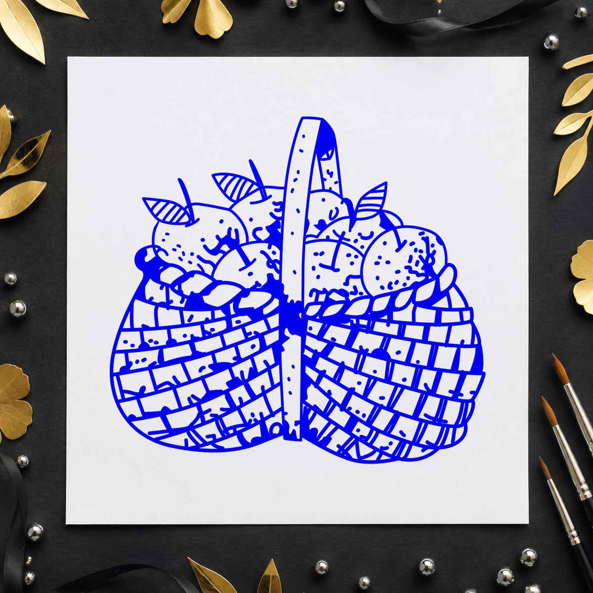 Basket Brimming with Apples Rubber Stamp impression in blue ink on white paper in a styled craft setting.