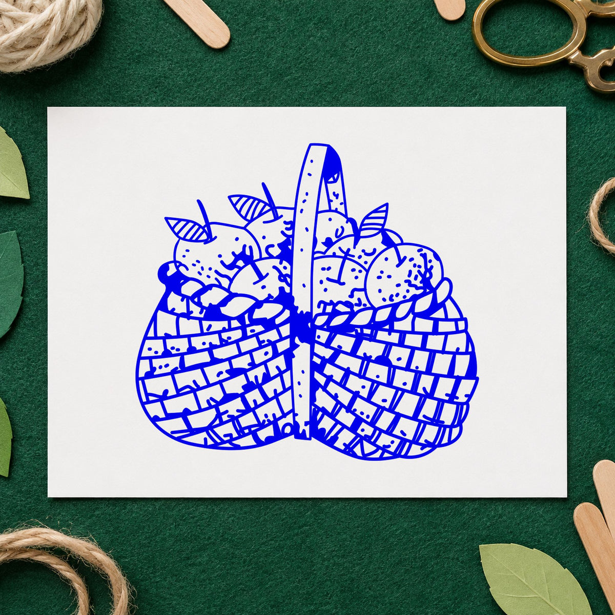 Blue harvest scrapbook stamp impression featuring the basket brimming with apples design on white paper.
