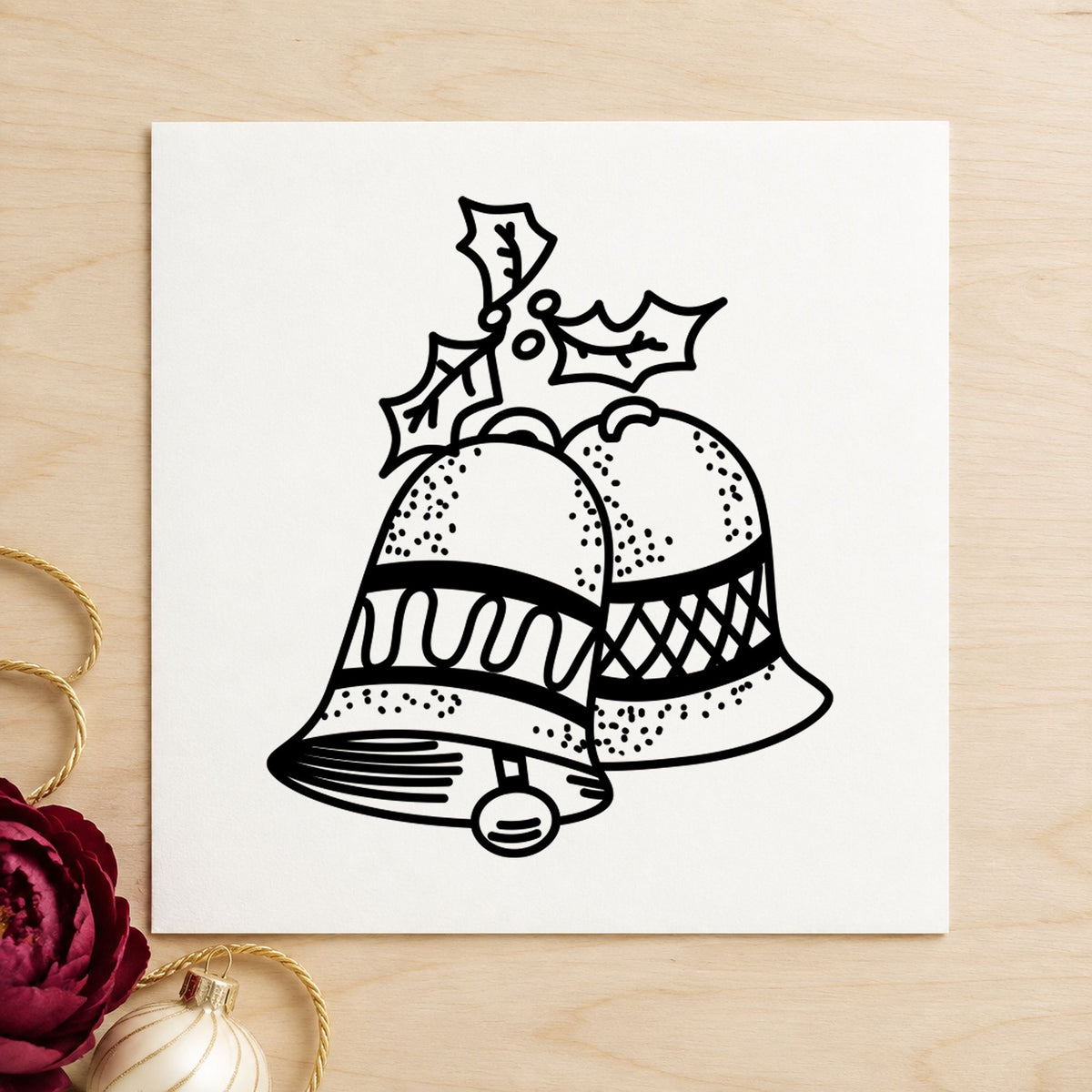 Christmas Bells with Mistletoe Rubber Stamp impression in black ink on white paper in a styled craft setting.