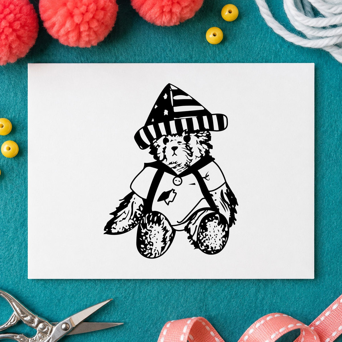 Bear in Stars and Stripes Hat Rubber Stamp impression in black ink on white paper in a styled craft setting.