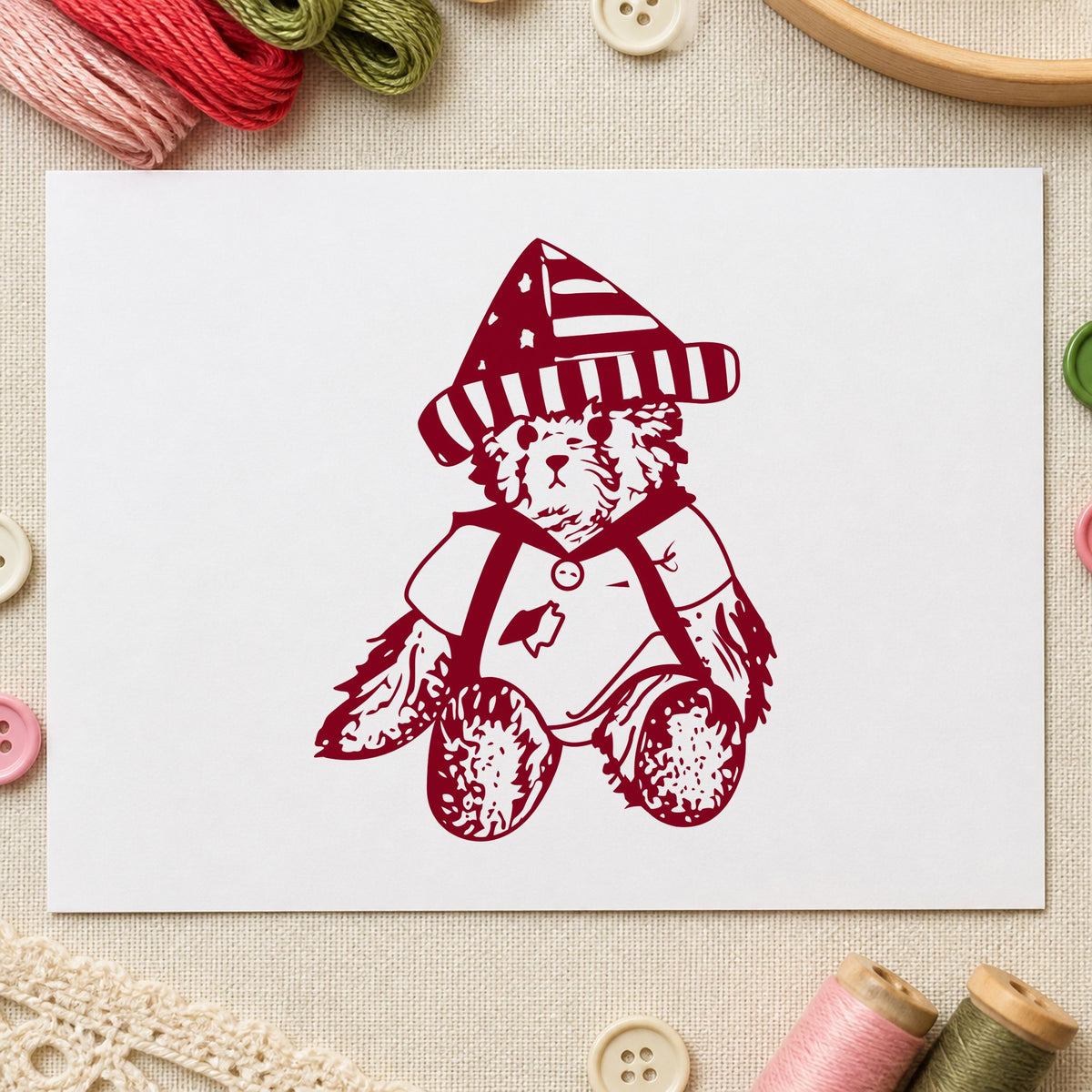 Bear in Stars and Stripes Hat Rubber Stamp impression in burgundy ink on white paper in a styled craft setting.