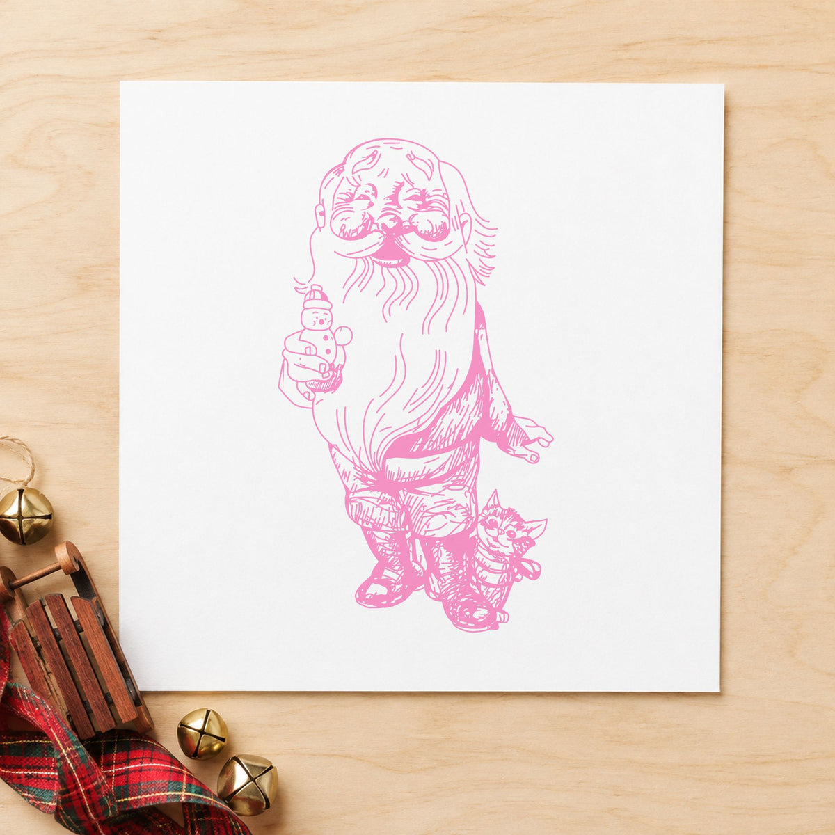 Santa with Kitten and Snowman Rubber Stamp impression in pink ink on white paper in a styled craft setting.