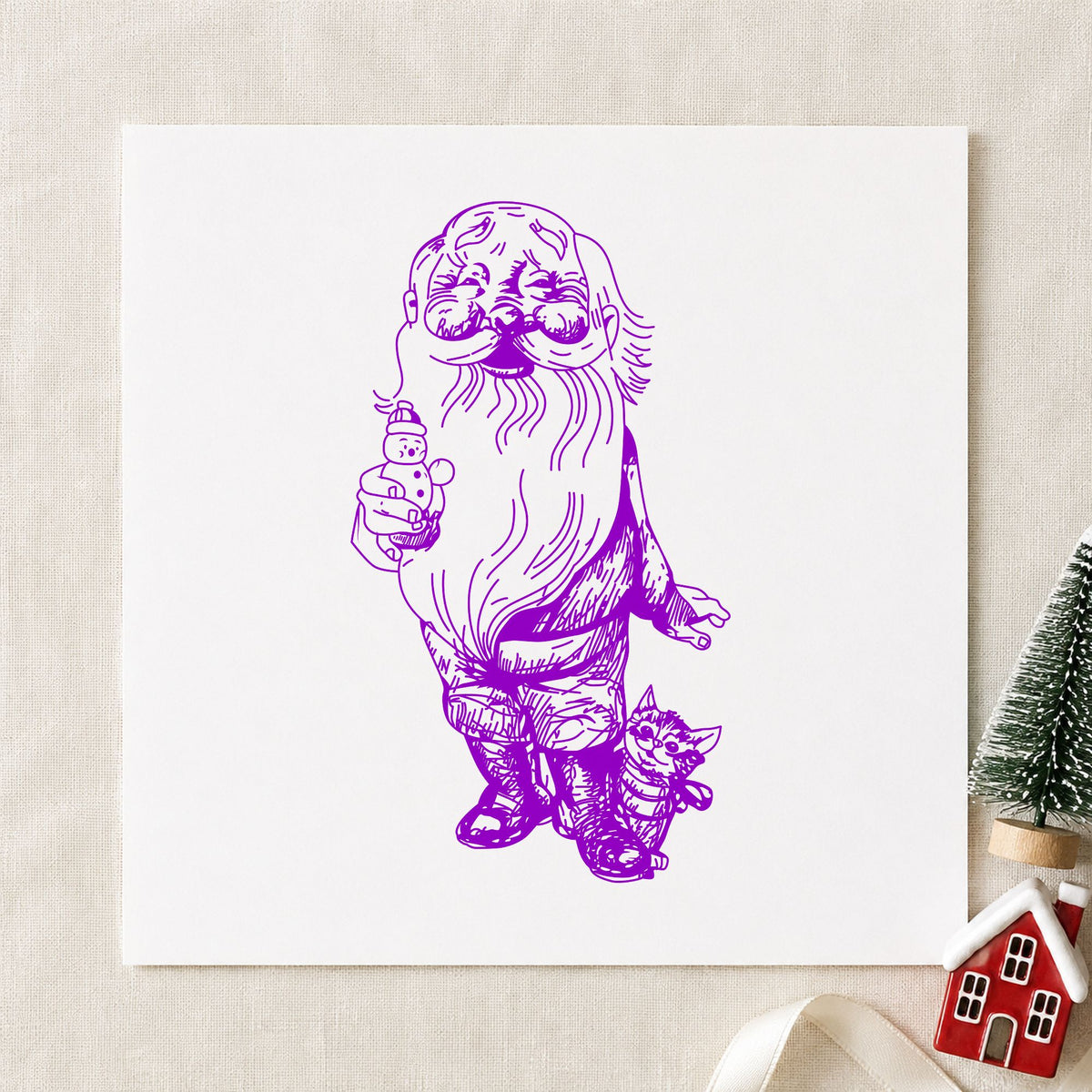 Santa with Kitten and Snowman Rubber Stamp impression in purple ink on white paper in a styled craft setting.