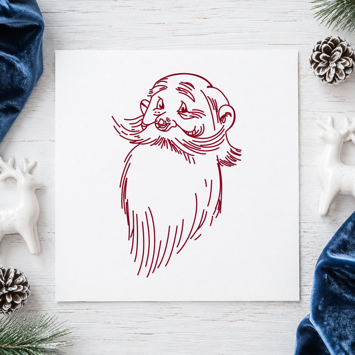Santa Claus Face Rubber Stamp impression in burgundy ink on white paper in a styled craft setting.