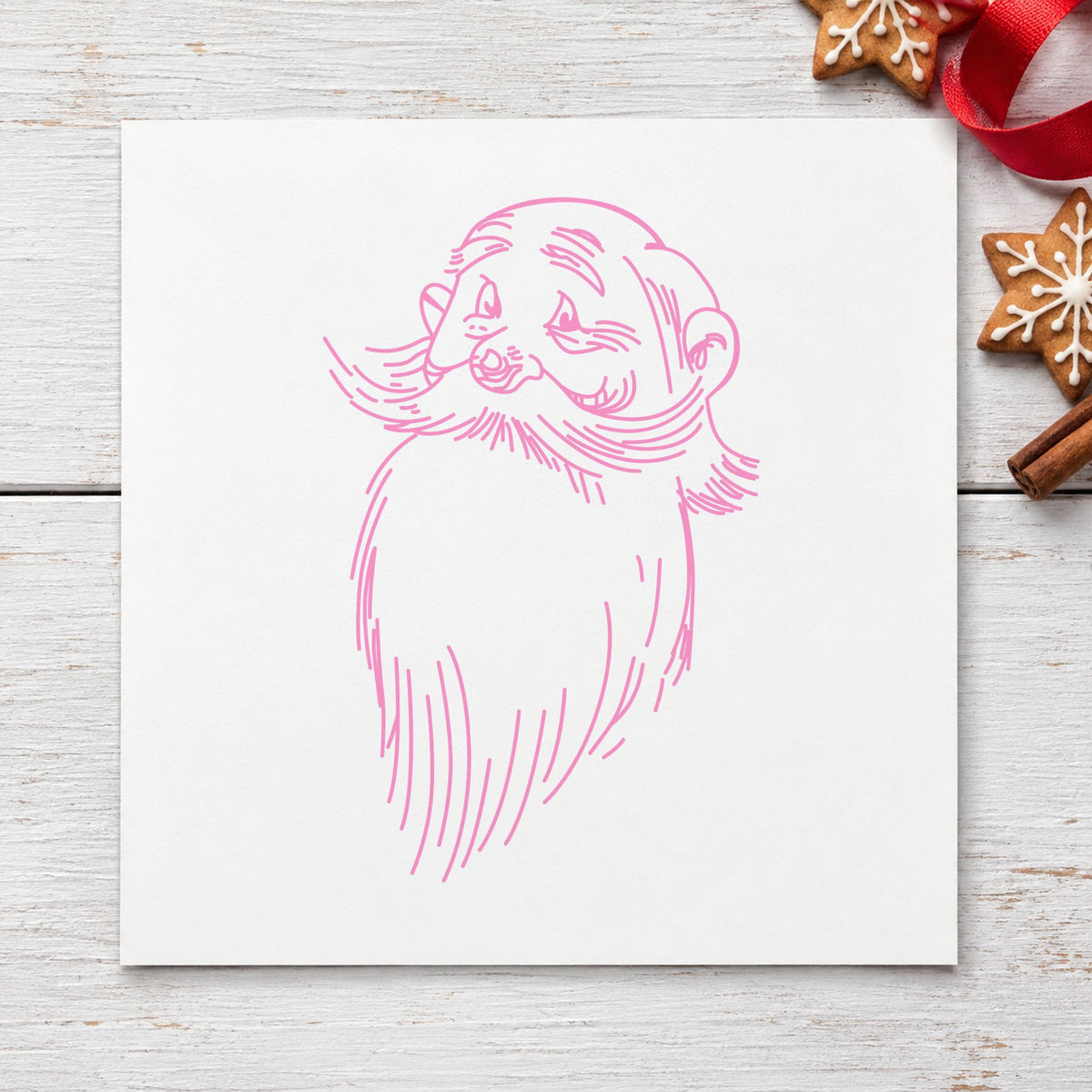 Santa Claus Face Rubber Stamp impression in pink ink on white paper in a styled craft setting.