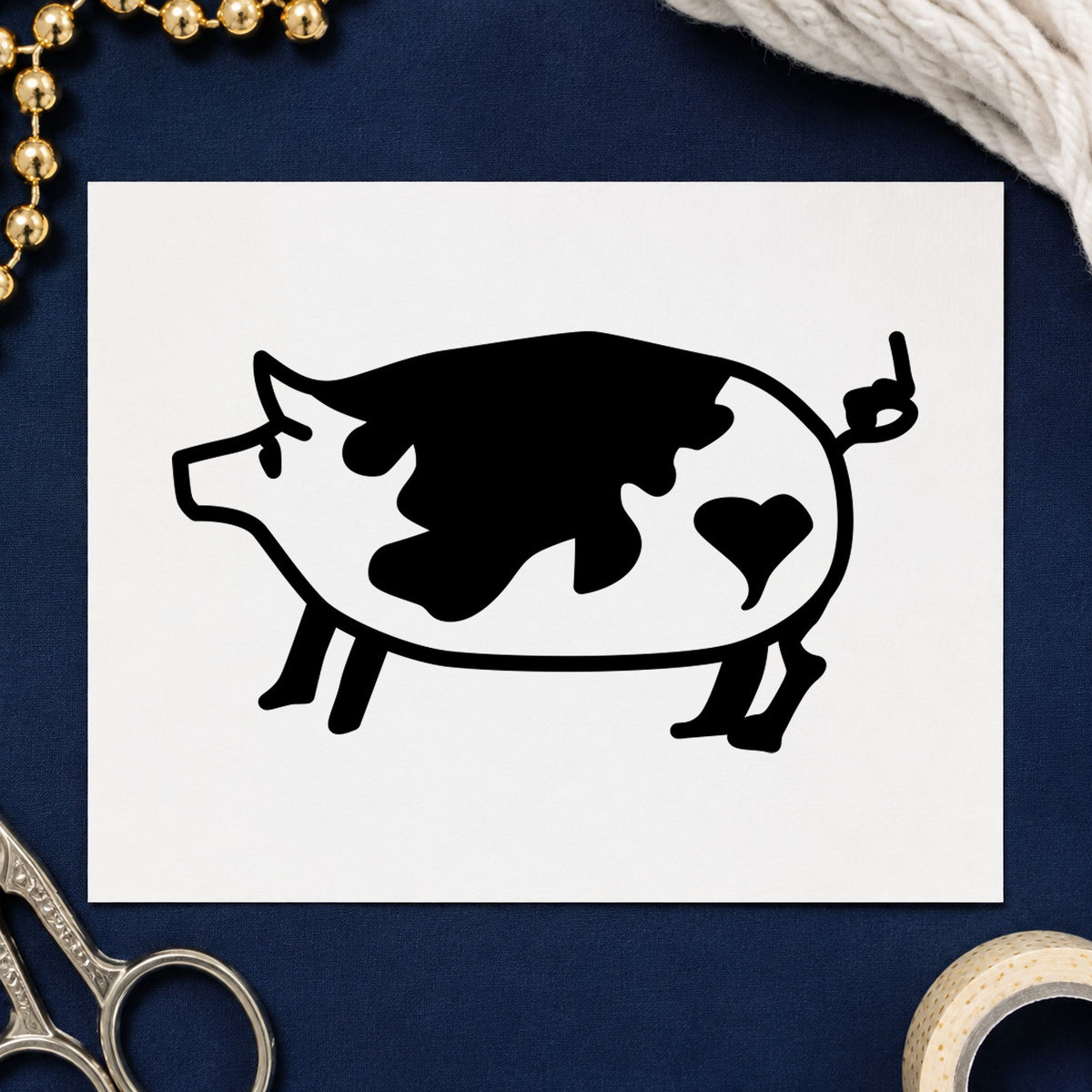 Spotted Pig with Heart Rubber Stamp impression in black ink on white paper in a styled craft setting.