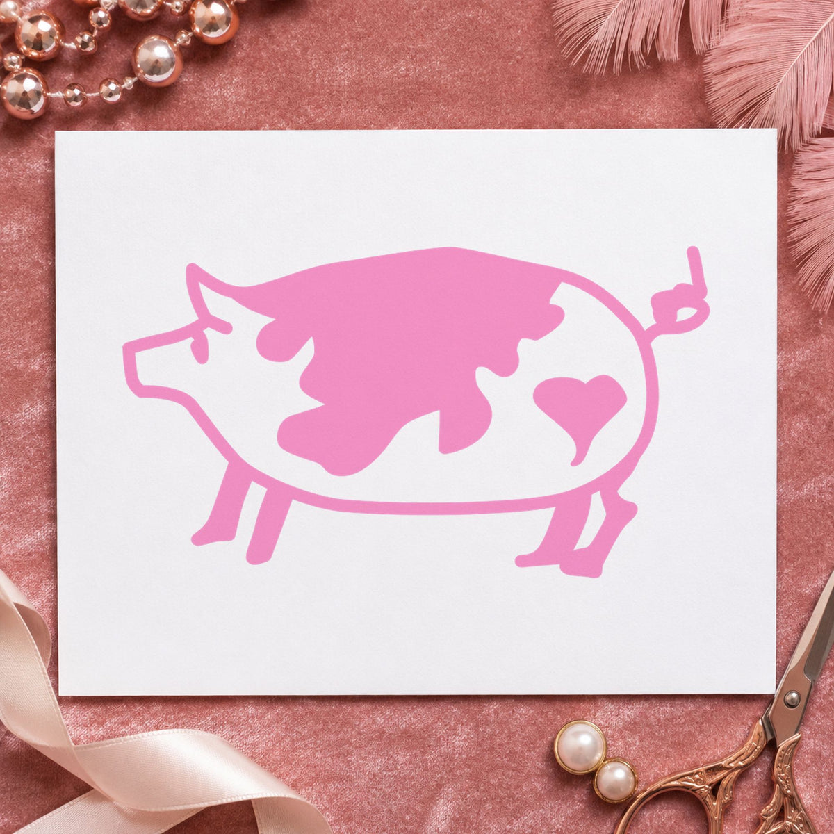 Spotted Pig with Heart Rubber Stamp impression in pink ink on white paper in a styled craft setting.