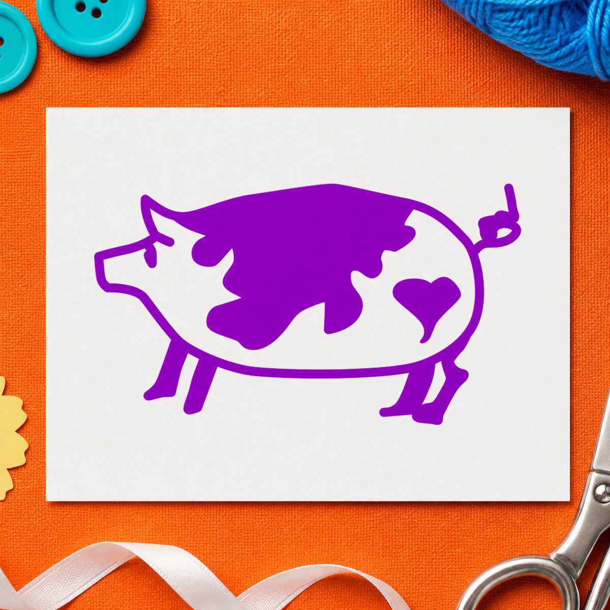 Spotted Pig with Heart Rubber Stamp impression in purple ink on white paper in a styled craft setting.
