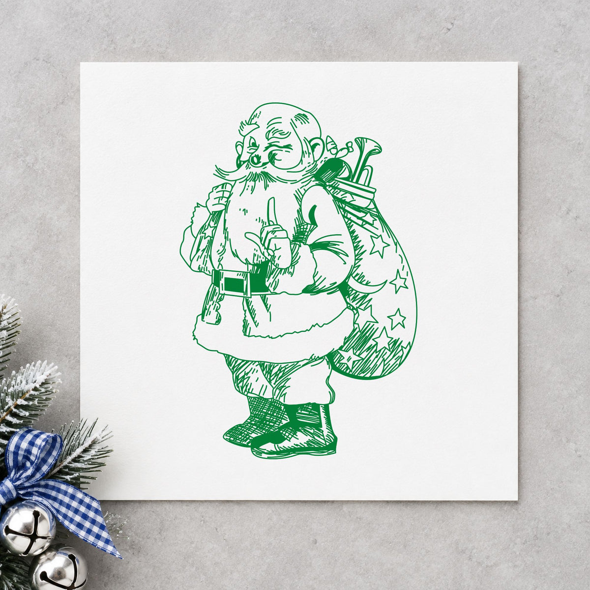 Santa with Gift Sack Rubber Stamp impression in green ink on white paper in a styled craft setting.