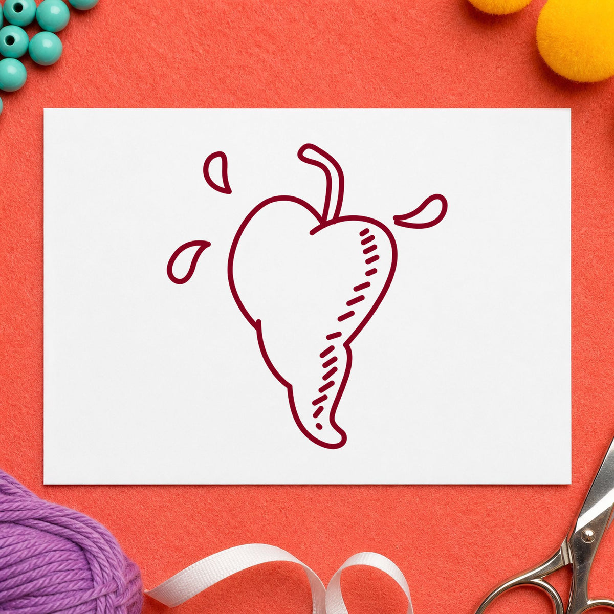 Heart-shaped Pepper Rubber Stamp impression in burgundy ink on white paper in a styled craft setting.