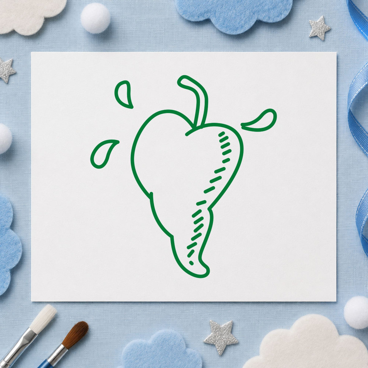 Heart-shaped Pepper Rubber Stamp impression in green ink on white paper in a styled craft setting.