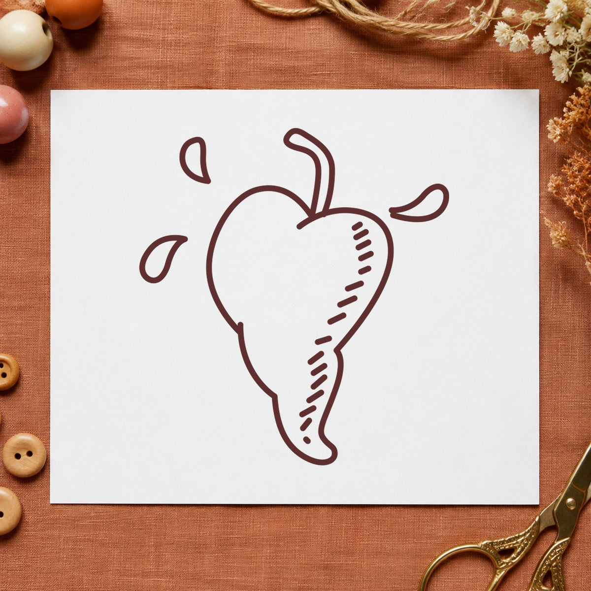 Heart-shaped Pepper Rubber Stamp impression in brown ink on white paper in a styled craft setting.