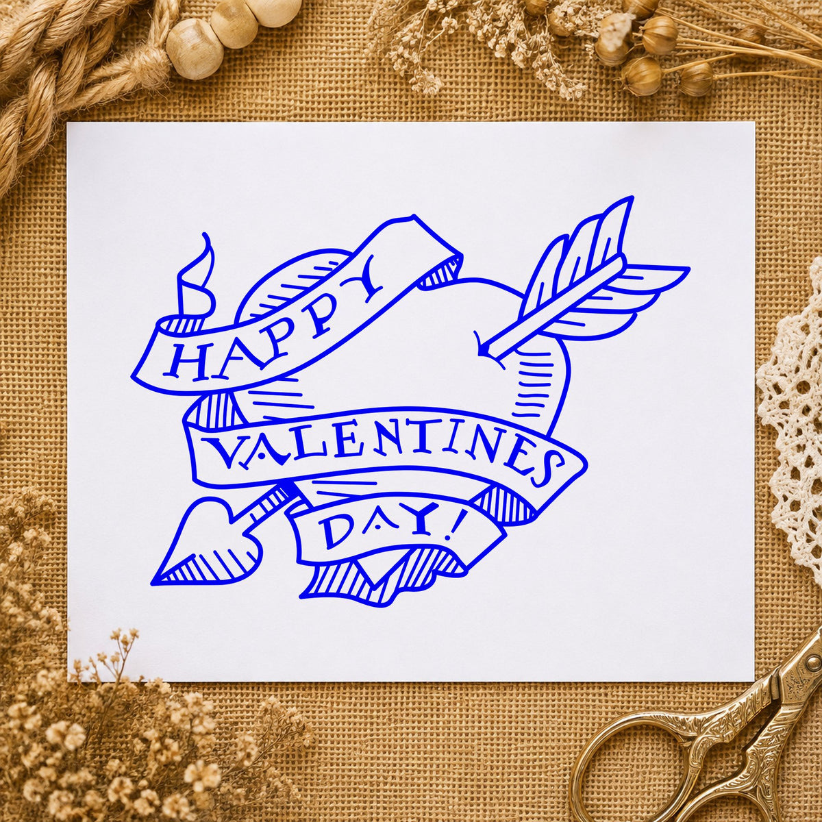 Valentine Heart with Arrow Rubber Stamp impression in blue ink on white paper in a styled craft setting.