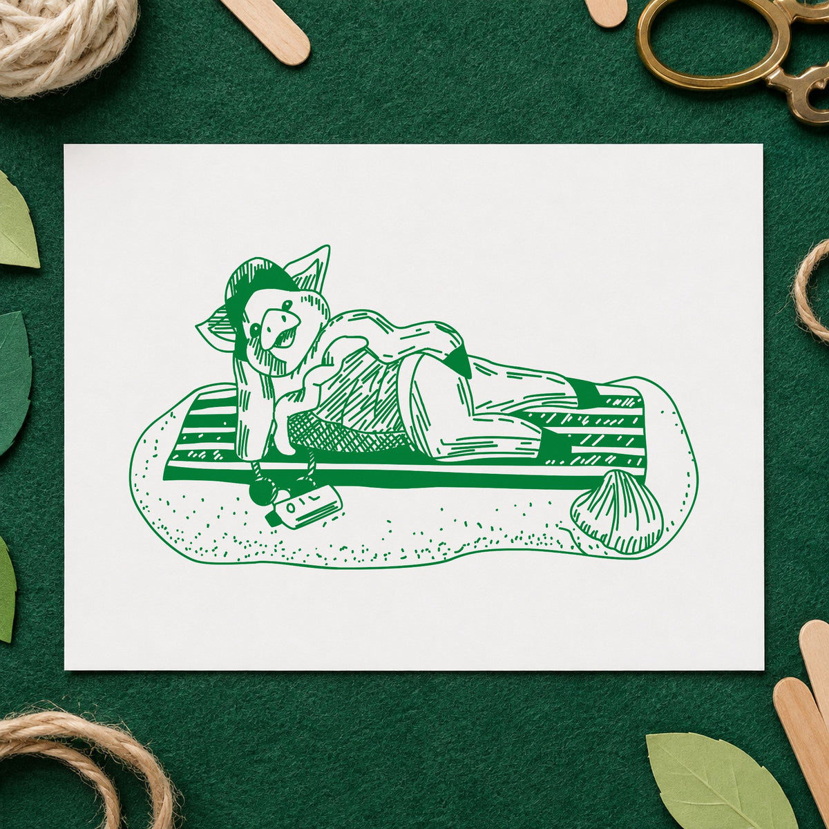 Pig on Beach Blanket Rubber Stamp impression in green ink on white paper in a styled craft setting.