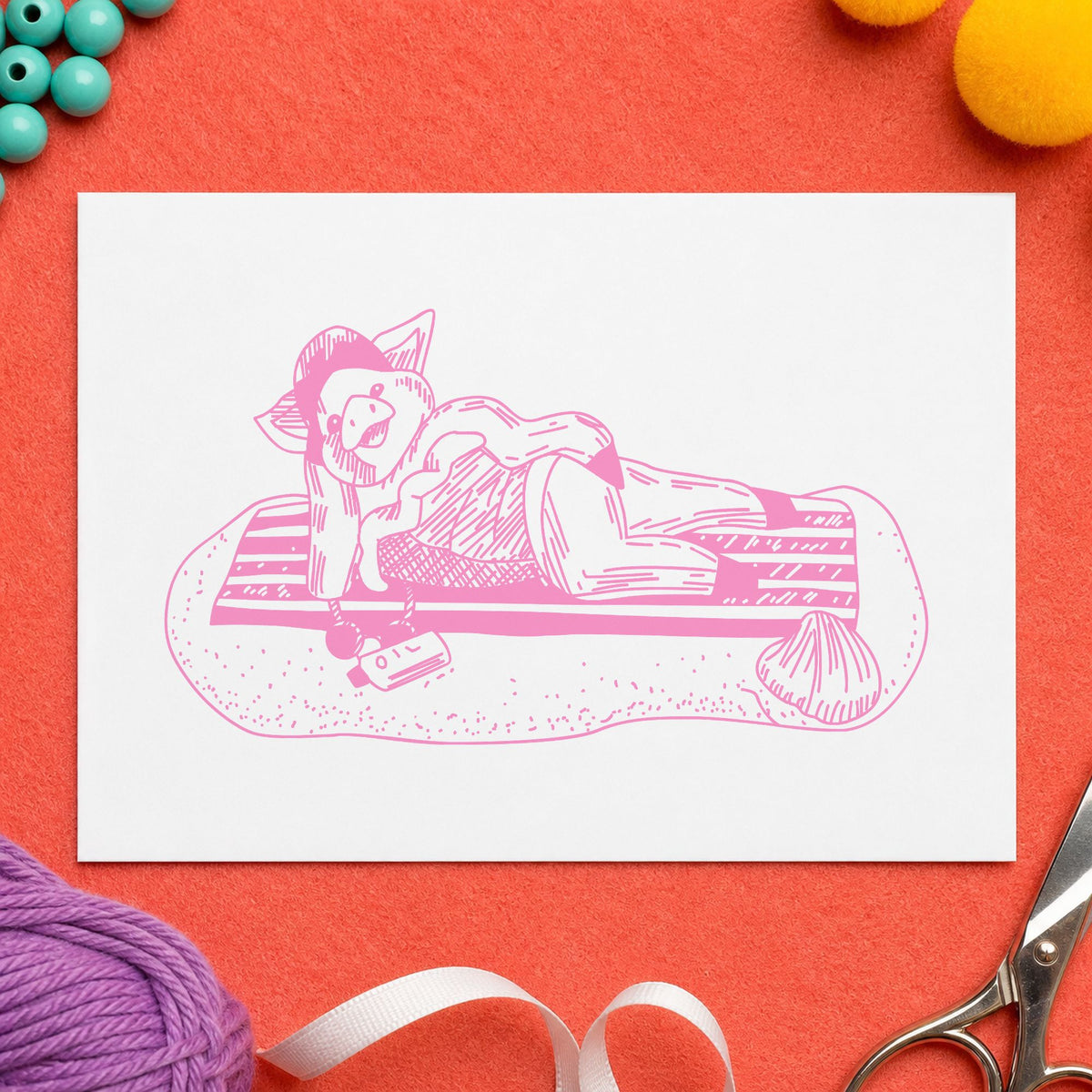 Pig on Beach Blanket Rubber Stamp impression in pink ink on white paper in a styled craft setting.
