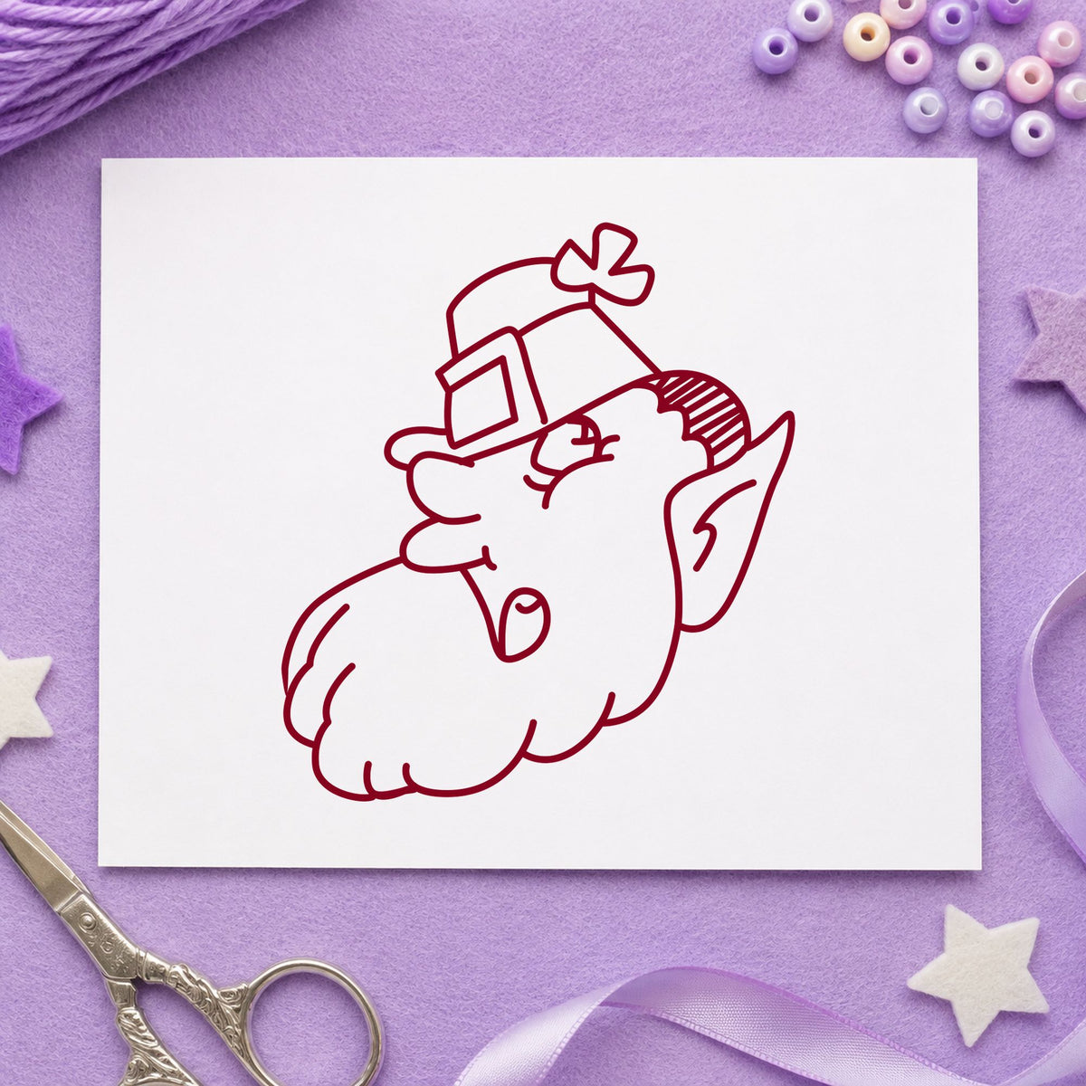 Leprechaun Head with Shamrock Hat Rubber Stamp impression in burgundy ink on white paper in a styled craft setting.