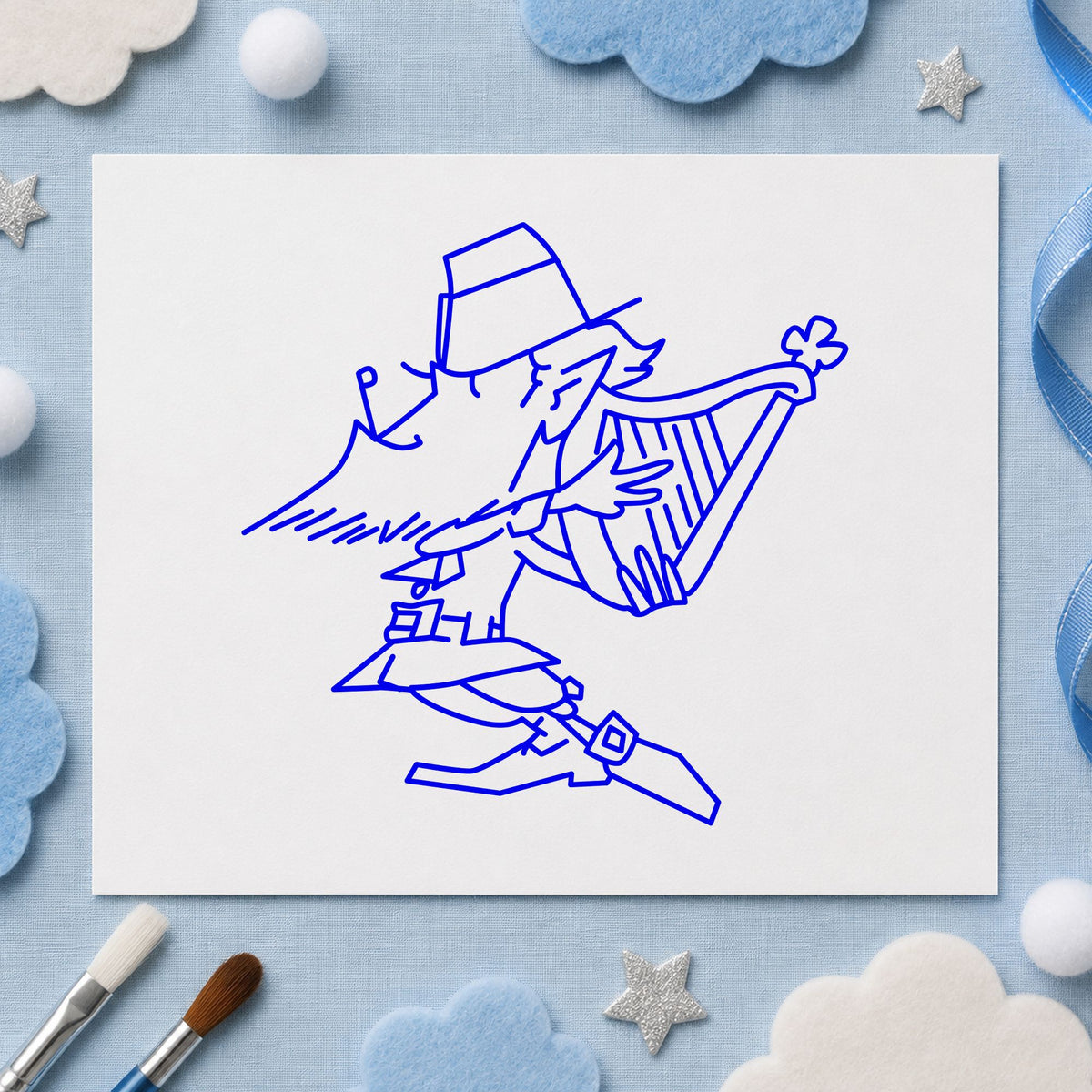 Leprechaun Playing Harp Rubber Stamp impression in blue ink on white paper in a styled craft setting.