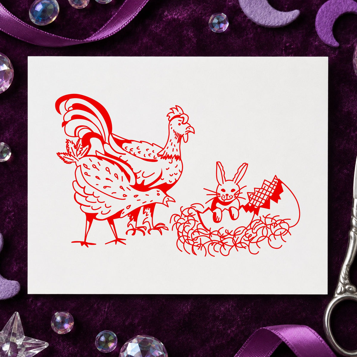 Chickens and Bunny in Easter Egg Rubber Stamp impression in red ink on white paper in a styled craft setting.