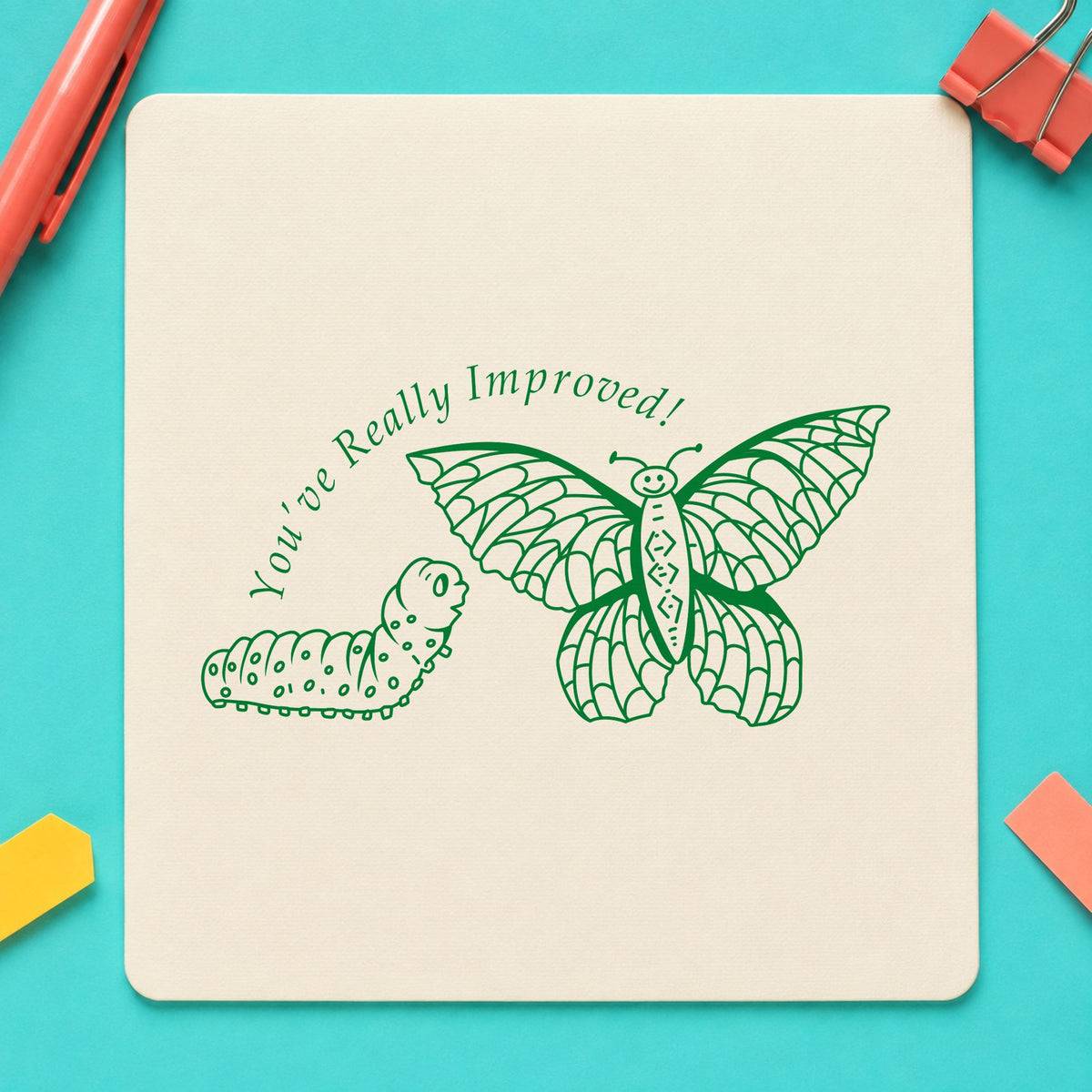 Youve Really Improved Butterfly and Caterpillar Rubber Stamp impression in green ink on white paper in a styled craft setting.