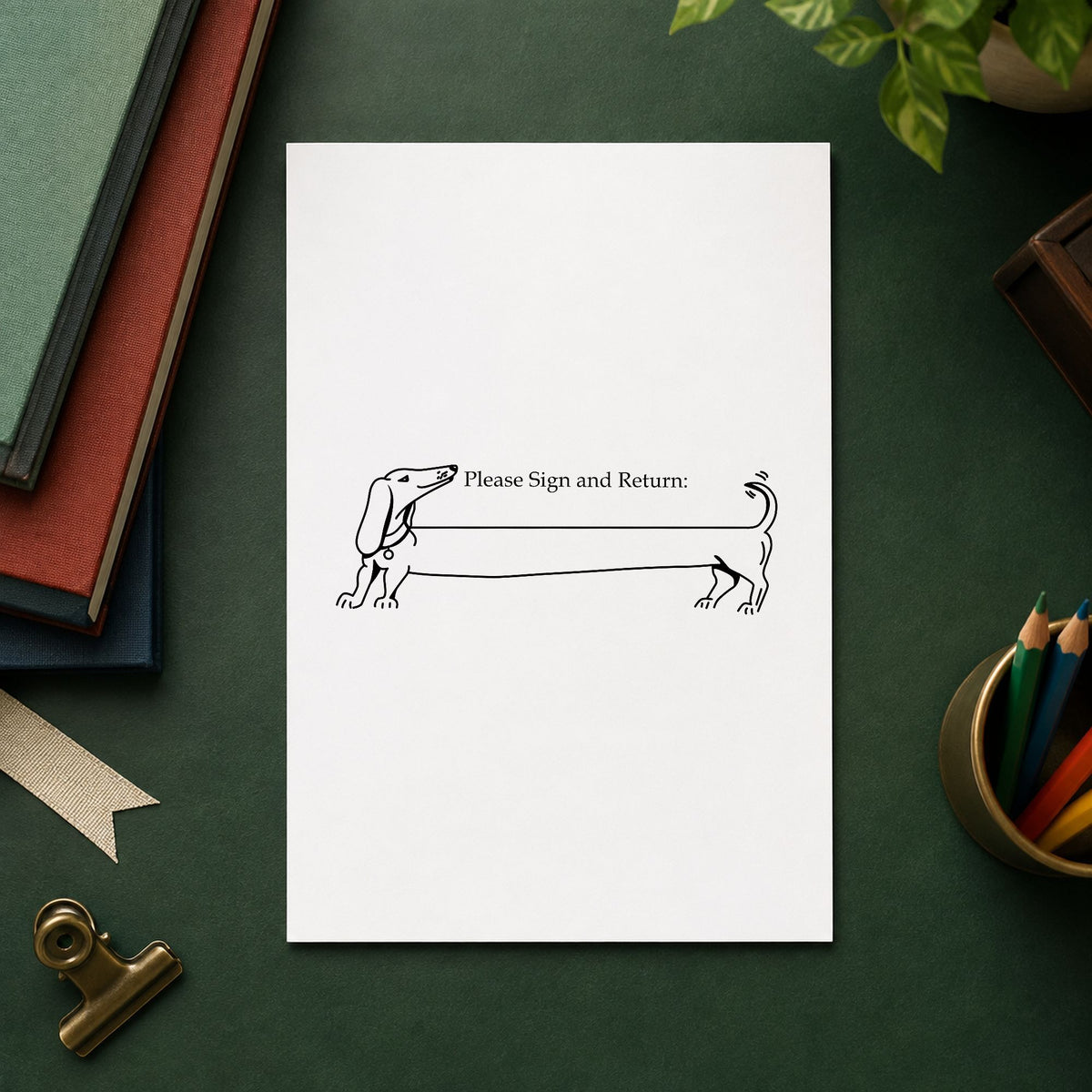 Please Sign and Return Dog Rubber Stamp impression in black ink on white paper in a styled craft setting.
