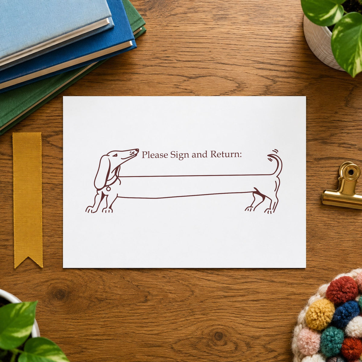 Please Sign and Return Dog Rubber Stamp impression in brown ink on white paper in a styled craft setting.