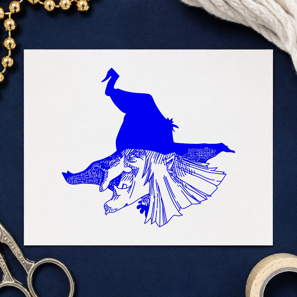 Witch Head with Hat Rubber Stamp impression in blue ink on white paper in a styled craft setting.