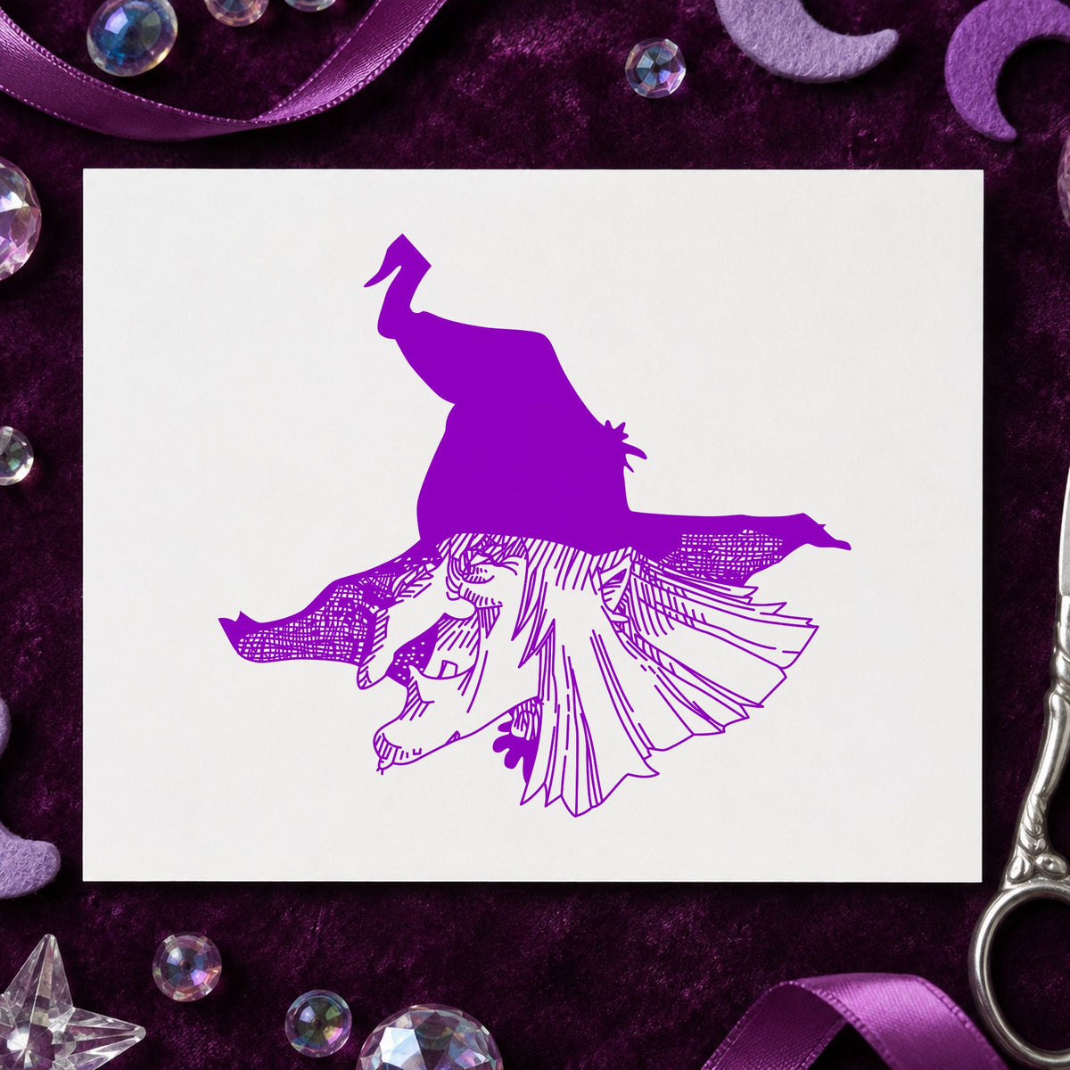 Witch Head with Hat Rubber Stamp impression in purple ink on white paper in a styled craft setting.