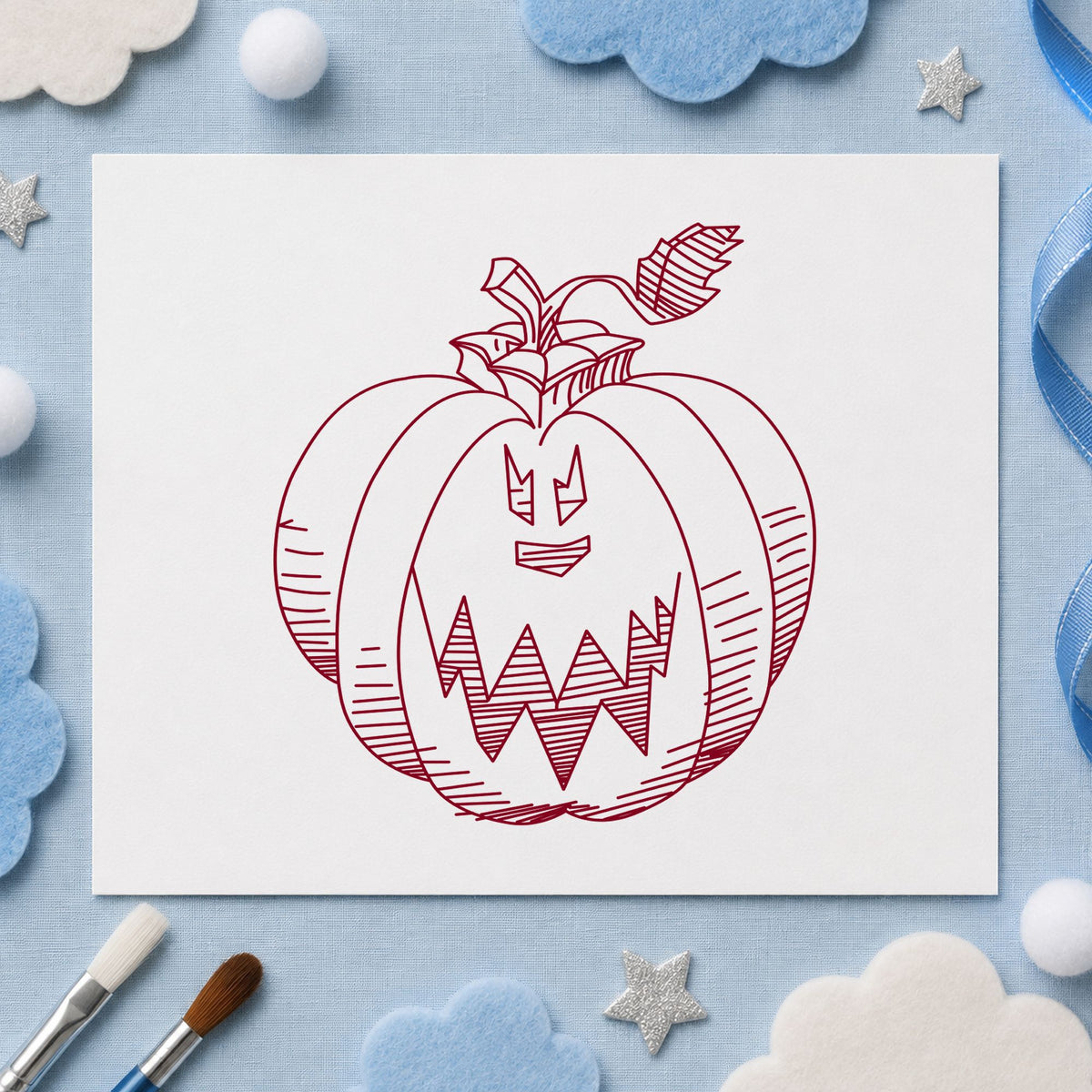 Scary Pumpkin Face Rubber Stamp impression in burgundy ink on white paper in a styled craft setting.