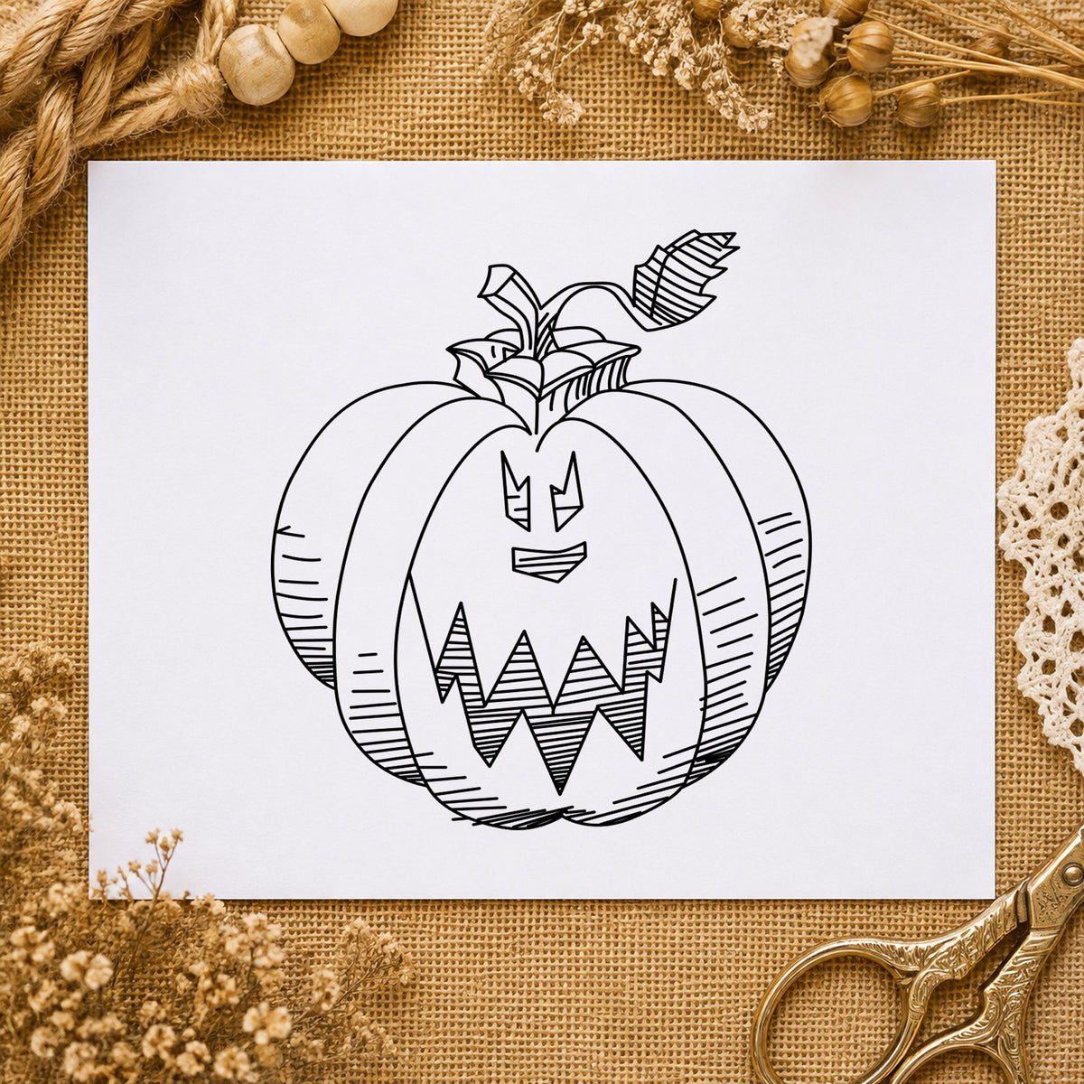 Black impression from a jack o'lantern stamp, featuring the scary pumpkin face design on white paper.