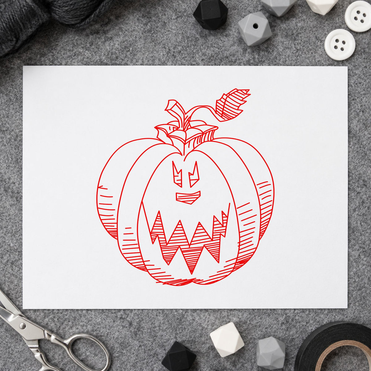 Scary Pumpkin Face Rubber Stamp impression in red ink on white paper in a styled craft setting.
