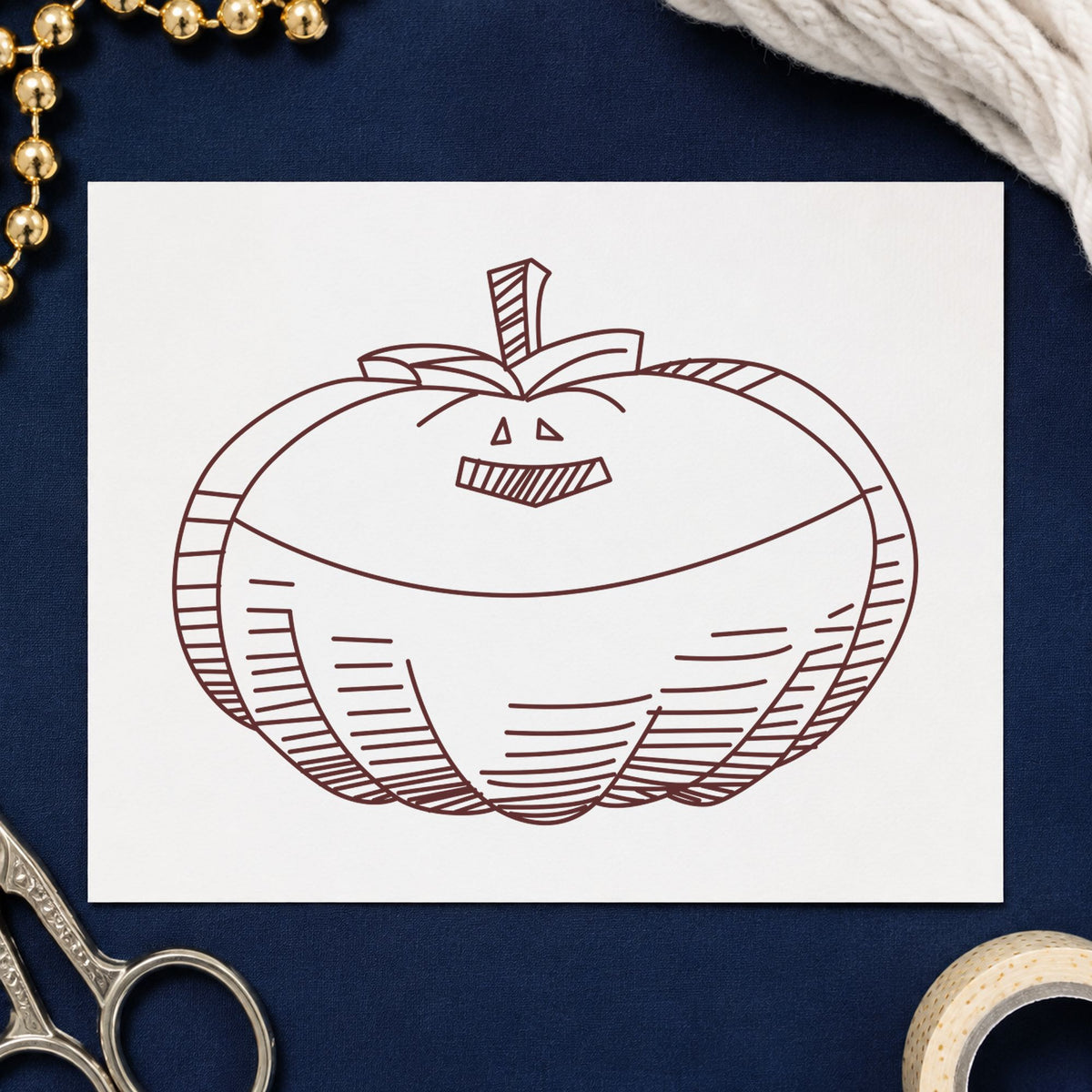 Smiling Jacko Lantern Rubber Stamp impression in brown ink on white paper in a styled craft setting.