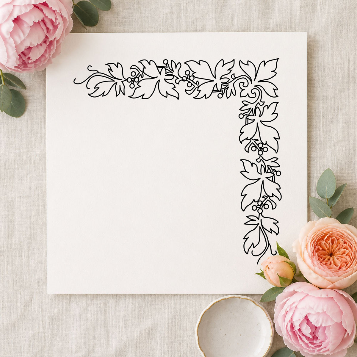 Black impression from a botanical border stamp, featuring the open leaf corner border design on white paper.