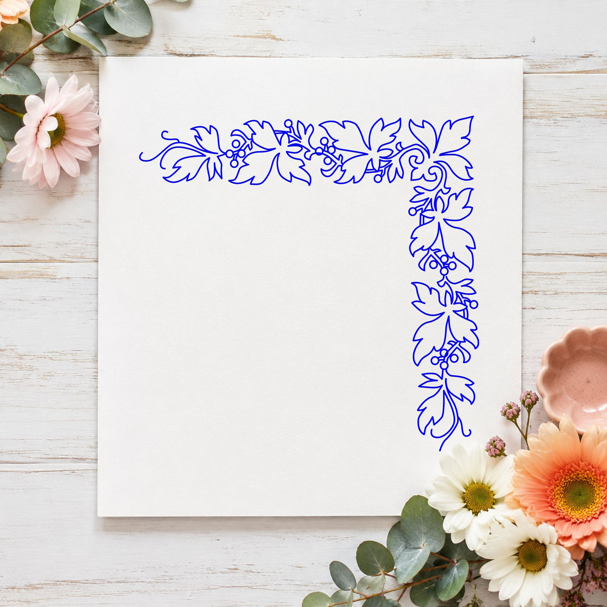 Open Leaf Corner Border Rubber Stamp impression in blue ink on white paper in a styled craft setting.