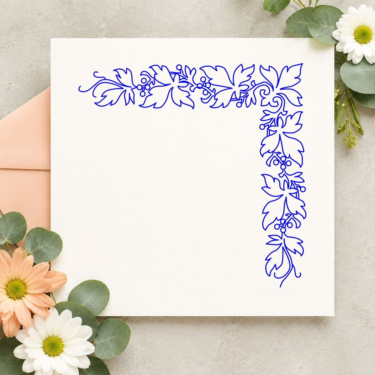Blue leaf craft stamp impression featuring the open leaf corner border design on white paper.