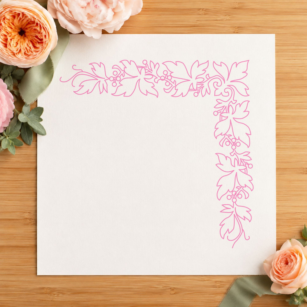 Open Leaf Corner Border Rubber Stamp impression in pink ink on white paper in a styled craft setting.