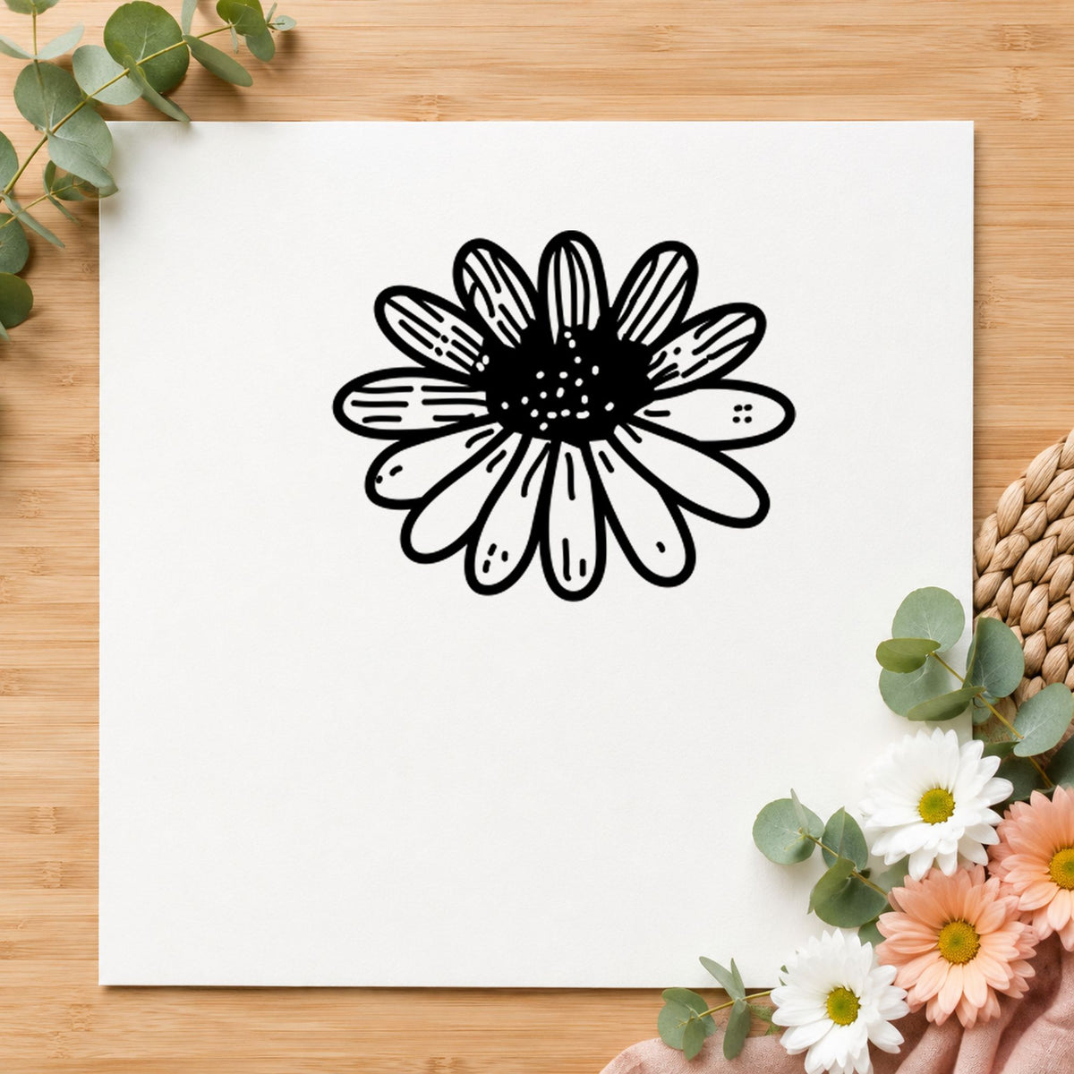 Black impression from a floral rubber stamp, featuring the daisy flower small design on white paper.