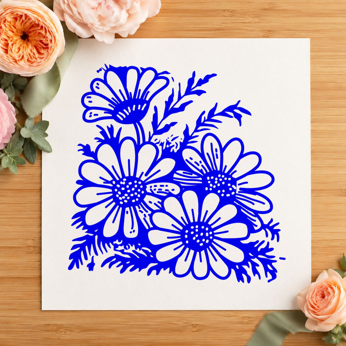 Four Daisy Blooms Rubber Stamp impression in blue ink on white paper in a styled craft setting.