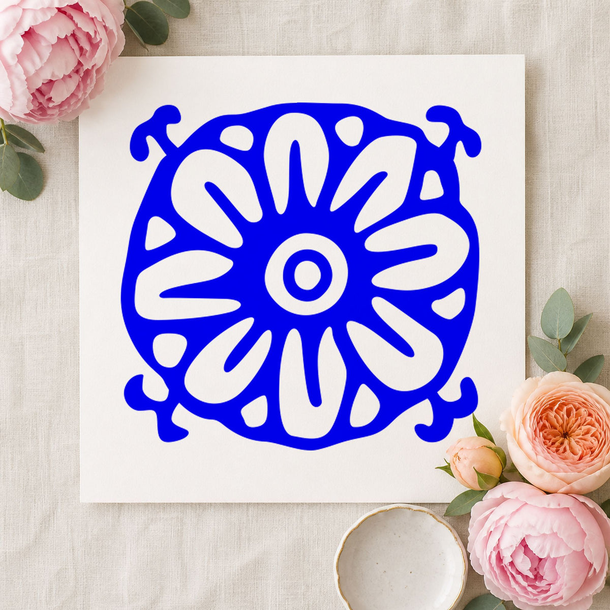 Blue decorative scrapbook stamp impression featuring the square flower motif design on white paper.