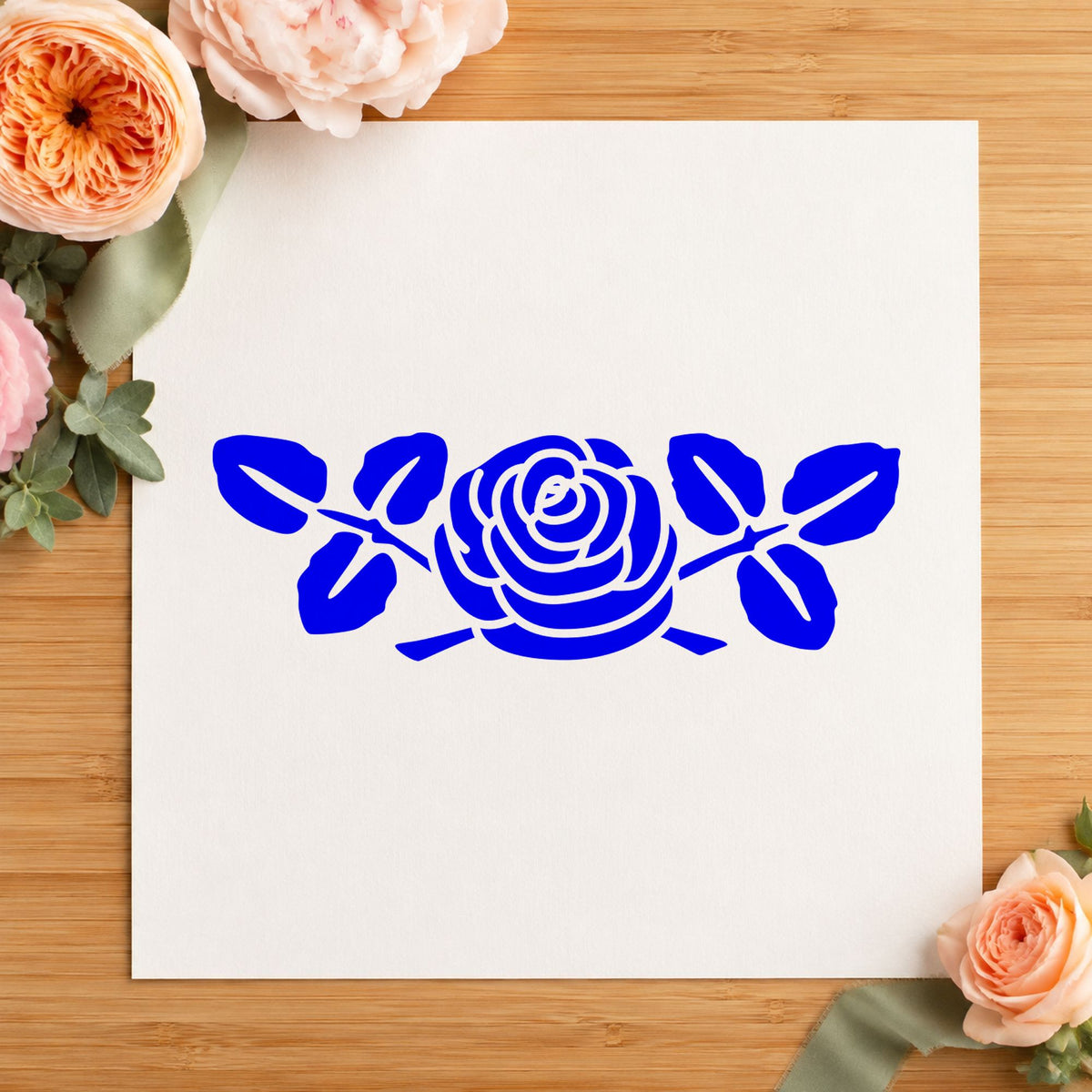 Rose Flower Rubber Stamp Large impression in blue ink on white paper in a styled craft setting.
