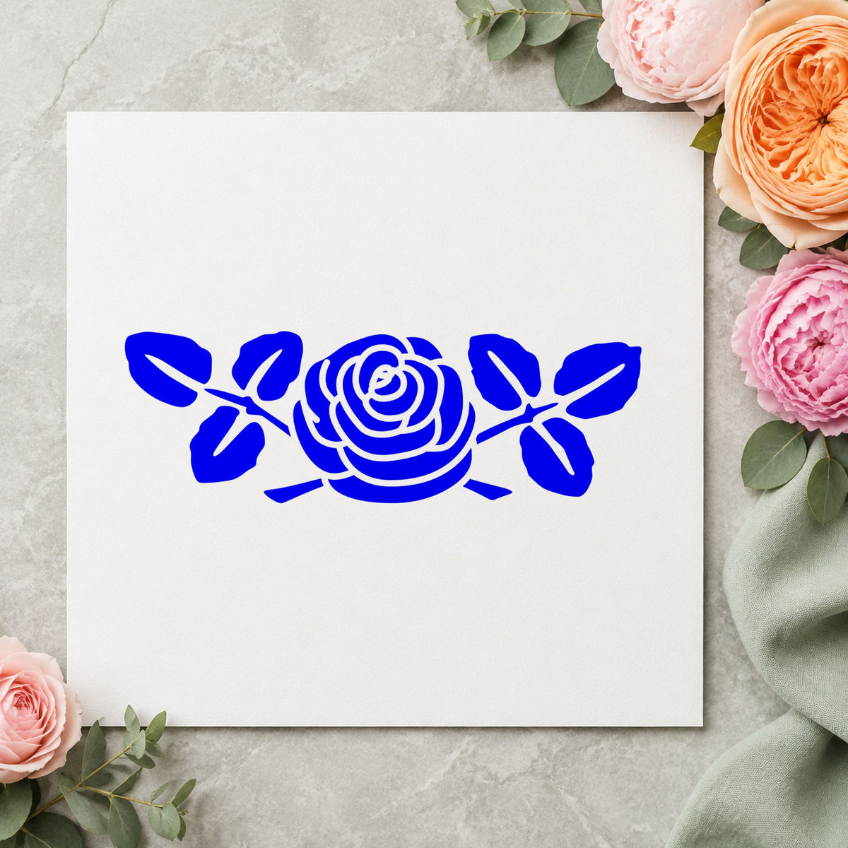 Blue flower card making stamp impression featuring the rose with leaves small design on white paper.