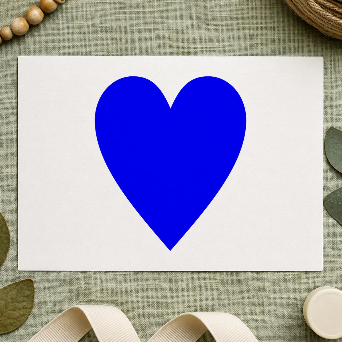 Blue playing card stamp impression featuring the playing card heart design on white paper.