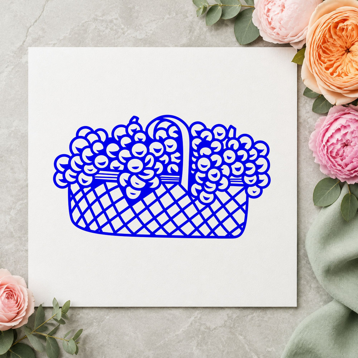 Basket of Flowers Rubber Stamp Large impression in blue ink on white paper in a styled craft setting.