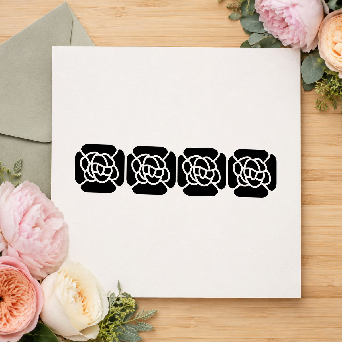 Four Solid Flowers Border Rubber Stamp impression in black ink on white paper in a styled craft setting.