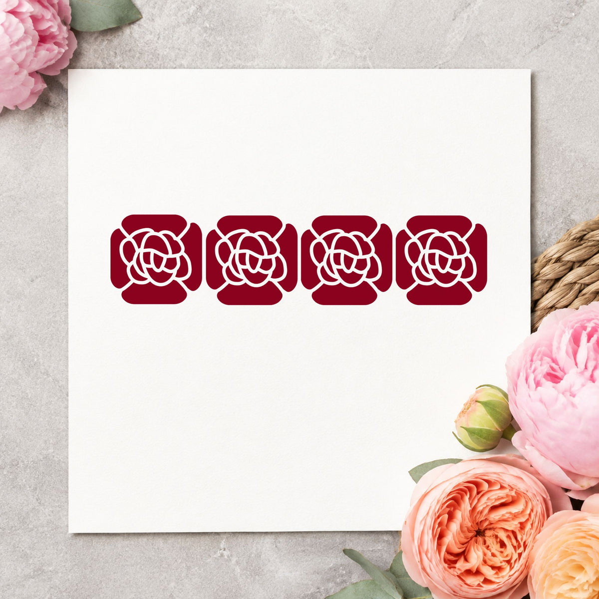 Four Solid Flowers Border Rubber Stamp impression in burgundy ink on white paper in a styled craft setting.