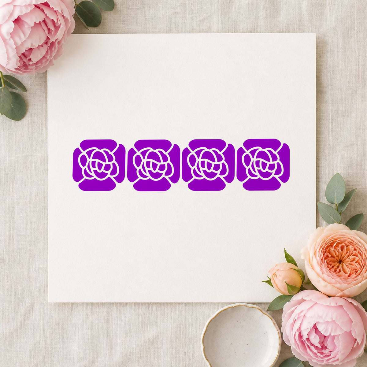 Four Solid Flowers Border Rubber Stamp impression in purple ink on white paper in a styled craft setting.